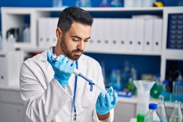 Young hispanic man scientist working at laboratory
