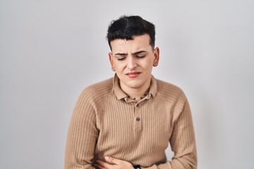 Obraz premium Non binary person standing over isolated background with hand on stomach because indigestion, painful illness feeling unwell. ache concept.
