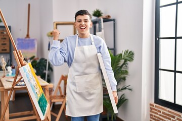 Non binary person at art studio screaming proud, celebrating victory and success very excited with raised arms