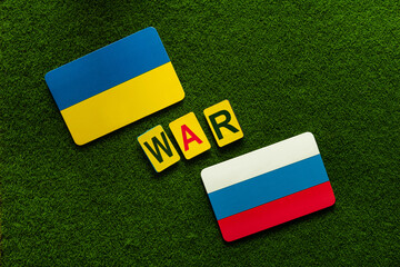 Fototapeta premium Ukraine Vs Russia. Symbol flags on a green lawn background.