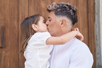 Father and daughter hugging each other and kissing at park