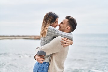 Man and woman couple smiling confident hugging each other at seaside - Powered by Adobe