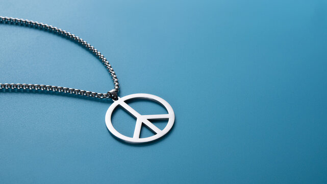 Metal medallion, with a pendant in the form of a symbol of peace on a blue background.