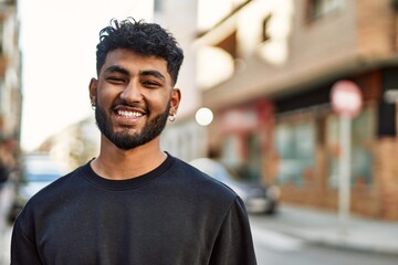 Young arab man smiling confident at street