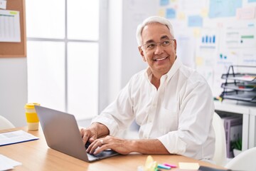 Middle age grey-haired man business worker using laptop working at office