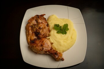 Close-up shot of a fried chicken thigh and mashed potatoes on a plate