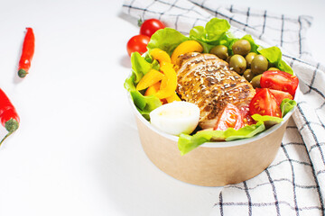 Buddha bowl salad with grilled chicken breast slices, cherry tomatoes, eggs, avocado, lettuce and seeds on light wooden background. Healthy food, clean eating, dieting