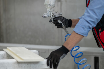 Close up picture of a man holding a spray gun