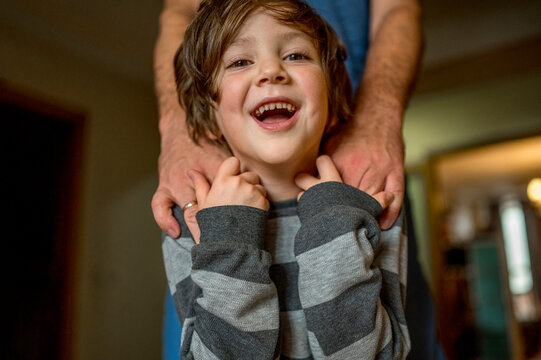 Hands of man on boy's shoulders at home