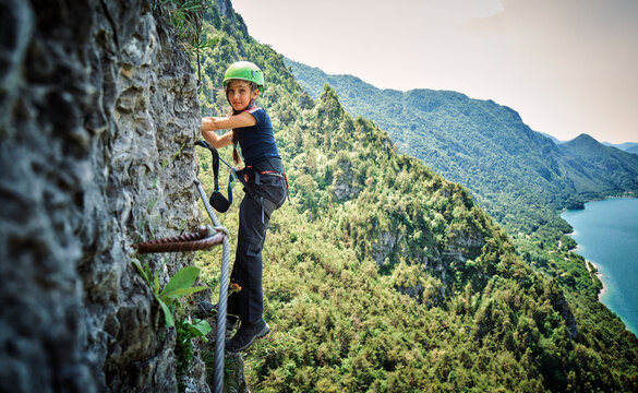 Girl wearing safety equipment climbing mountain