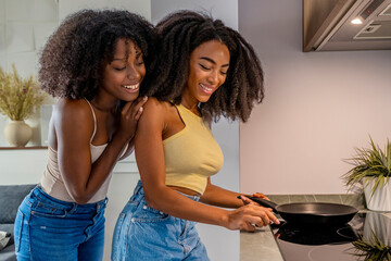 Smiling lesbian couple cooking together in kitchen