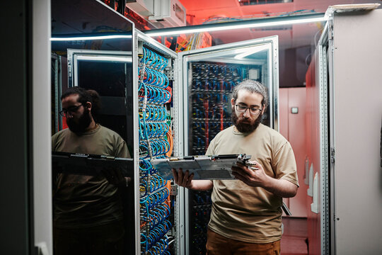 Computer technician checking machine part in data center