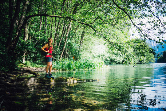 Hiker looking at Lake Levico standing under tree shade