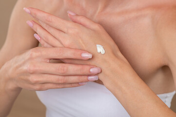 Fototapeta na wymiar Close up of female hand applying cream