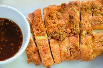 grilled slice chicken breast on plate dipping with spicy sauce 