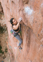 Focused woman jumping while rock climbing (dyno) - 1 