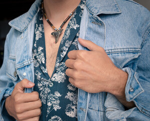Badass man wearing shark tooth necklace on hairy chest and denim