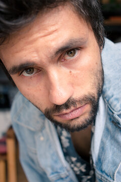 Thoughtful bearded man looks straight at camera