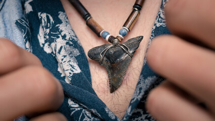 Close-up of man wearing shark tooth necklace