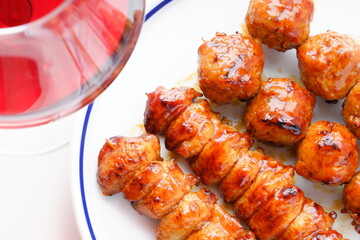 炭火でじっくり焼き上げた焼き鳥（タレ）と赤ワインのグラス