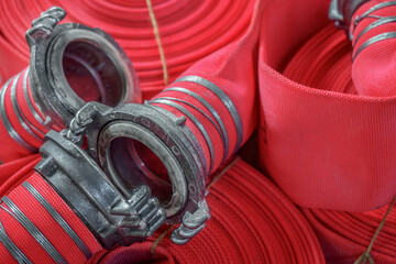 View of many twisted red fire hoses close-up in full screen. New fire extinguishing equipment....