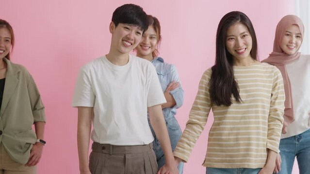 Asia people LGBT young adult Gen Z couple hold hand love care trust look at camera in Women's day studio shot pride month. Gay gender asian woman power unity cool team group happy smile photo shoot.