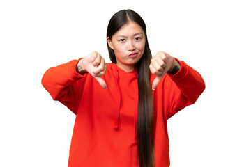 Young Asian woman over isolated background making stop gesture and disappointed