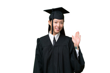 Young university graduate Asian woman over isolated background saluting with hand with happy expression