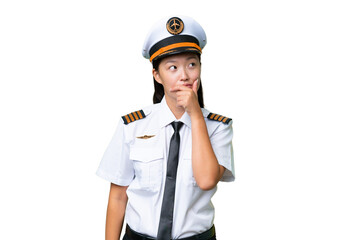 Airplane pilot Asian woman over isolated background having doubts and with confuse face expression