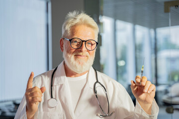 old man gray hair doctor holds syringe with vaccine
