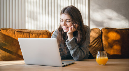 Attractive young woman working on a laptop early in the morning.