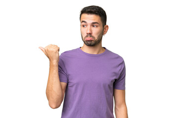 Fototapeta premium Young handsome caucasian man over isolated background unhappy and pointing to the side