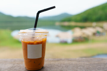 Delicious Thai iced tea. mockup empty logo blank space on the wood. The backdrop of the accommodation is relaxing, with tourist attractions, and natural reservoirs. leave space for you