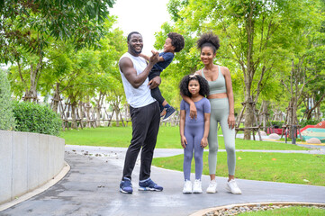 Portrait of Happy African American smiling family resting and having fun after workout outdoors,...