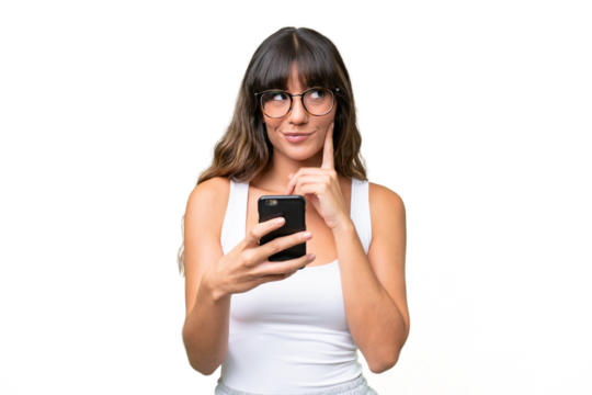 Young caucasian woman over isolated background using mobile phone and thinking