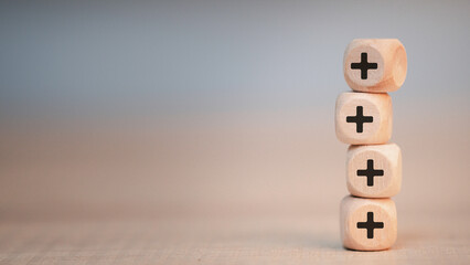 Plus sign in wooden cube block stacking. Addition and positive mindset thinking  such as profit,...