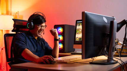 Professional Asian male gamer playing video games on personal pc computer. Colorful neon light room. Esport online game. © NVB Stocker