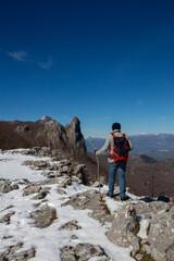 Hiker on the summit of a mountain with snow on the Alburni mountains (SA)