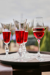 Glasses with red wine on a tray.