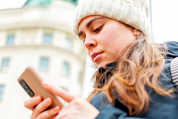 Young caucasian woman texting on the smart phone.