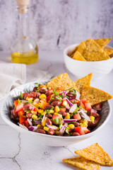 Mexican vegetable salad cowboy caviar and nachos in a bowl on the table. Vertical view