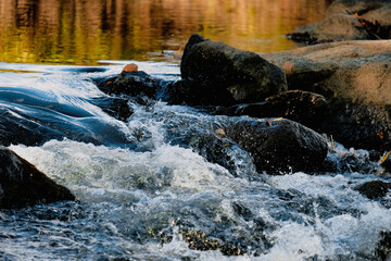 Turbulent water, calm river and red and green reflections.