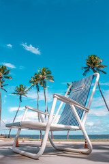 Vertical photo of Giant chair with coconut trees and sea in the background - Tourist spot on the...