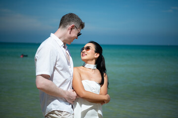 Fototapeta na wymiar Interracial couple with the joy of traveling to the beautiful blue sea like the paradise