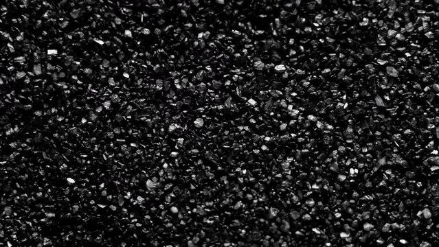 Black sand moving. Close-up of a black sand surface moving.