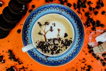 Tuinposter Top view of a Cappuccino with art on an orange table with cookies © Ssayeed Bin Mohiuddin/Wirestock Creators