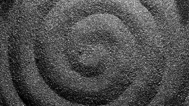 Black sand moving. Close-up of a black sand surface moving.