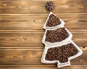 Happy New Year 2023. Christmas pine nuts in saucers in the form of a Christmas tree. Christmas wooden background