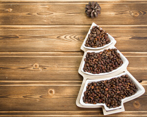 Happy New Year 2023. Christmas pine nuts in saucers in the form of a Christmas tree. Christmas wooden background