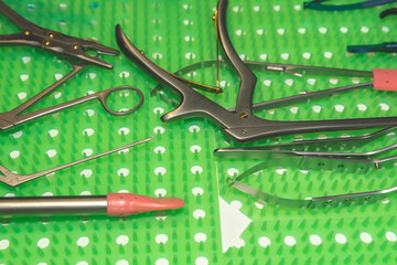 Surgical instruments on a green medical grade silicone finger mat.